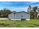 Charming single-story house with blue siding, an irrigation system, lush green yard, and a paved driveway at 215 Portia N St, Nokomis, FL 34275
