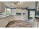 Bright kitchen features white cabinetry, tile backsplash, laminate countertops, wood-look flooring, and modern lighting at 215 Portia N St, Nokomis, FL 34275