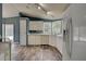 Bright kitchen features white cabinetry, tile backsplash, laminate countertops, wood-look flooring, and modern appliances at 215 Portia N St, Nokomis, FL 34275