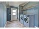 This is a laundry room with a side-by-side washer and dryer, metal shelving, and a glass paneled door at 215 Portia N St, Nokomis, FL 34275