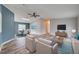Bright living room featuring new flooring, a ceiling fan, and modern furniture at 215 Portia N St, Nokomis, FL 34275