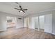 This is a bedroom with light grey walls, wood floors, a ceiling fan, and walk-in closet with mirrored doors at 215 Portia N St, Nokomis, FL 34275
