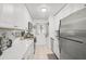 Bright galley kitchen featuring white cabinets and stainless steel appliances at 4160 Fruitville Rd # 14, Sarasota, FL 34232