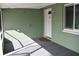 Enclosed front porch with gray flooring and a view of the front door at 907 Shasta Rd, Venice, FL 34293