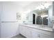 Double vanity bathroom with white cabinets and a large mirror at 9401 President Cir, Port Charlotte, FL 33981