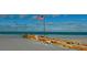 Beachfront view with American flag and old wooden structure at 9401 President Cir, Port Charlotte, FL 33981