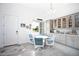 Bright breakfast nook features a white table and blue chairs, built in cabinets and views to the backyard at 9401 President Cir, Port Charlotte, FL 33981