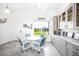 Bright breakfast nook features a white table and blue chairs, built in cabinets and views to the backyard at 9401 President Cir, Port Charlotte, FL 33981