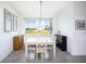 Bright dining area with light blue table and four chairs, features a large window with a view at 9401 President Cir, Port Charlotte, FL 33981