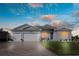 Two-car garage, light gray house, blue door, and landscaped lawn at 9401 President Cir, Port Charlotte, FL 33981