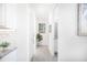 Bright hallway with light grey tile flooring and beach themed art at 9401 President Cir, Port Charlotte, FL 33981