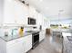 Modern white kitchen with granite countertops and stainless steel appliances at 9401 President Cir, Port Charlotte, FL 33981