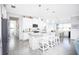 Modern white kitchen with granite counters, stainless steel appliances, and an island at 9401 President Cir, Port Charlotte, FL 33981