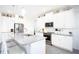 Modern white kitchen with granite counters, stainless steel appliances, and an island at 9401 President Cir, Port Charlotte, FL 33981