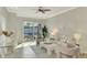 Living room with neutral decor, ceiling fan and access to a private patio at 9847 Haze Dr, Venice, FL 34292