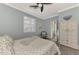 Bright bedroom with a queen bed, window shutters, and an armoire at 9855 Haze Dr, Venice, FL 34292