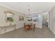 Open dining room with glass-top table and kitchen view at 9855 Haze Dr, Venice, FL 34292