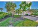 Landscaped front yard with tropical plants and a brick driveway at 9855 Haze Dr, Venice, FL 34292