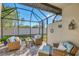 Relaxing screened patio with wicker furniture and paver floor at 9855 Haze Dr, Venice, FL 34292