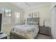 Cozy bedroom with a gray upholstered bed, leafy decor and ample natural light at 10055 Crooked Creek Dr # 102, Venice, FL 34293