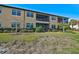 Building exterior showcasing a well-maintained lawn and balconies at 10055 Crooked Creek Dr # 102, Venice, FL 34293
