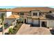 Three-unit building with attached garages, paver driveway, and tropical landscaping at 10055 Crooked Creek Dr # 102, Venice, FL 34293