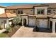 Three-unit building with attached garages and tropical landscaping at 10055 Crooked Creek Dr # 102, Venice, FL 34293