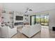 Bright living room features a fireplace, built-in shelving, and sliding glass doors leading to a patio at 10055 Crooked Creek Dr # 102, Venice, FL 34293