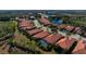 Aerial perspective of a residential community featuring houses with tile roofs and lush landscaping at 115 Avalini Way, North Venice, FL 34275