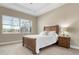 Cozy bedroom with a wooden bed frame and neutral decor at 115 Avalini Way, North Venice, FL 34275