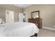 Well-lit bedroom with a dresser and access to another room at 115 Avalini Way, North Venice, FL 34275