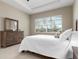 Bright bedroom featuring a queen-size bed and large windows at 115 Avalini Way, North Venice, FL 34275