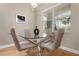 Bright dining room featuring a glass-top table and four chairs at 115 Avalini Way, North Venice, FL 34275