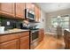 Modern kitchen with stainless steel appliances and light wood cabinets at 115 Avalini Way, North Venice, FL 34275