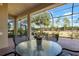 Covered patio with seating area, overlooking a lush green backyard at 115 Avalini Way, North Venice, FL 34275