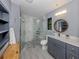 Updated bathroom with gray vanity, walk-in shower, and pebble floor at 1363 Brookside Dr, Venice, FL 34285