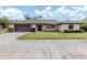 Single-story home with a brown roof, attached garage, and well-manicured lawn at 1363 Brookside Dr, Venice, FL 34285