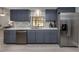Modern kitchen with gray cabinets, stainless steel appliances, and quartz countertops at 1363 Brookside Dr, Venice, FL 34285