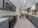 Modern kitchen with gray cabinets, stainless steel appliances, and quartz countertops at 1363 Brookside Dr, Venice, FL 34285