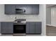 Modern kitchen with gray cabinets, stainless steel appliances, and white countertops at 1363 Brookside Dr, Venice, FL 34285
