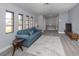 Living room with a blue sofa, gray floors, and ample natural light at 1363 Brookside Dr, Venice, FL 34285