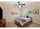 Bedroom with ceiling fan, large bed, and window views at 19718 Cobblestone Cir, Venice, FL 34292