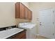 Laundry room with washer, dryer, cabinets and utility sink at 19718 Cobblestone Cir, Venice, FL 34292