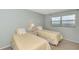 Bedroom with two twin beds, nightstand, and window with blinds at 255 The Esplanade N # 603, Venice, FL 34285