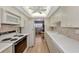 Modern kitchen with white cabinets, tiled backsplash, and built-in appliances at 255 The Esplanade N # 603, Venice, FL 34285