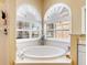 Bathroom with large circular tub, arched windows, and white tile at 305 Rio Terra, Venice, FL 34285