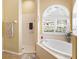Bathroom features a large garden tub, walk-in shower, and arched windows at 305 Rio Terra, Venice, FL 34285