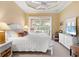 Bright bedroom with white bedding, sliding door to balcony, and dresser at 305 Rio Terra, Venice, FL 34285