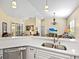 Open kitchen with stainless steel sink, quartz counters, and a view into the living area at 305 Rio Terra, Venice, FL 34285