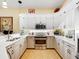 Bright kitchen featuring stainless steel oven and microwave, white cabinets, and stone countertops at 305 Rio Terra, Venice, FL 34285